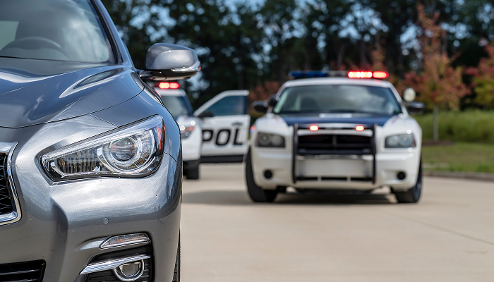 A police car parked beside a civilian car on a city street